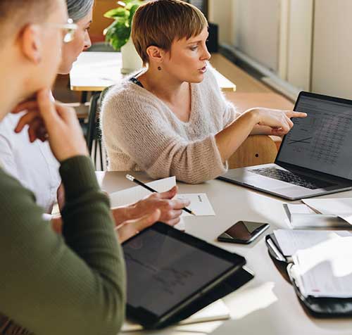 Mujer ejecutiva presentando unos datos a su equipo de trabajo durante una reunión